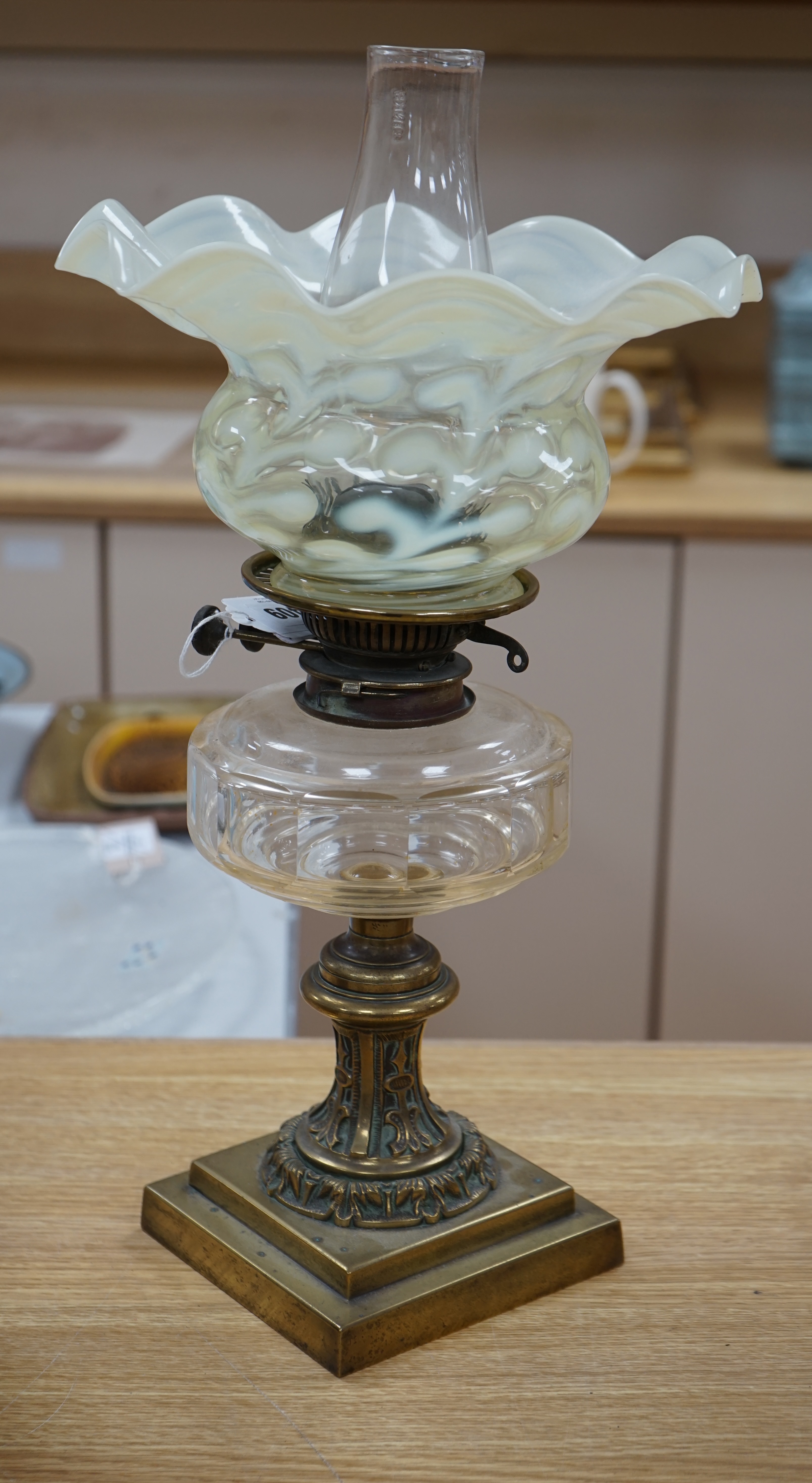 A brass oil lamp with glass reservoir and Art Nouveau vaseline glass fluted shade, 48cm high. Condition - good